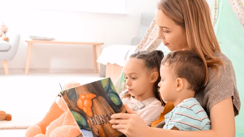 Woman reading to two children cuddled up in her arms