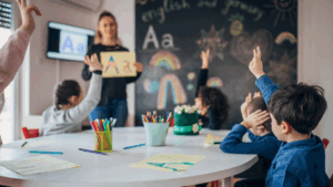 students raising their hands in the classroom