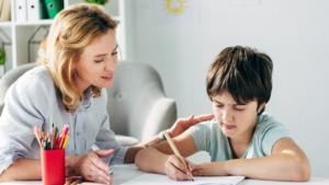 Teacher helps a student with a writing activity.