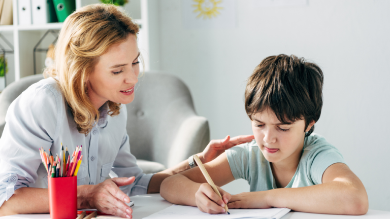 Teacher helps a student with a writing activity.